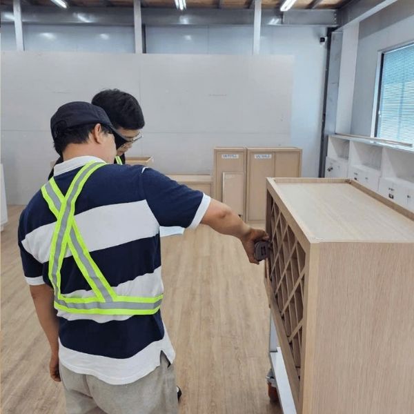 worker inspecting cabinet quality in manufacturing facility