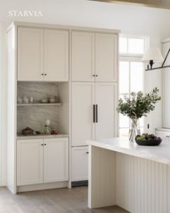 Modern shaker cabinets in a contemporary kitchen design featuring white cabinetry and brass hardware