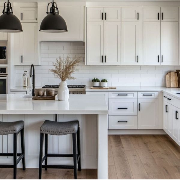 Modern kitchen featuring white shaker kitchen cabinets and black hardware